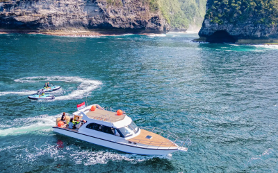 A yacht passing by the impressive cliffs of Nusa Penida.